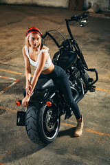 Obraz premium Fashion shooting with white young female posting on big motorcycle.