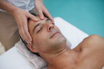Resort, spa and man relax for massage on table in hotel, calm and care for body in vacation....