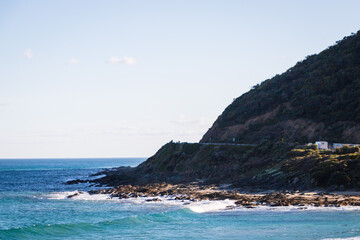 Fototapeta premium Rocky Shoreline Embrace: The Ocean’s Melodic Whisper