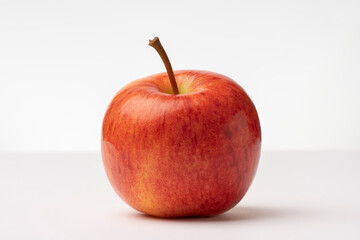 A fresh beautiful healthy apple on a white table with light gray background