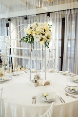 A beautiful vase of flowers on a table in a luxury restaurant. Wedding decorations