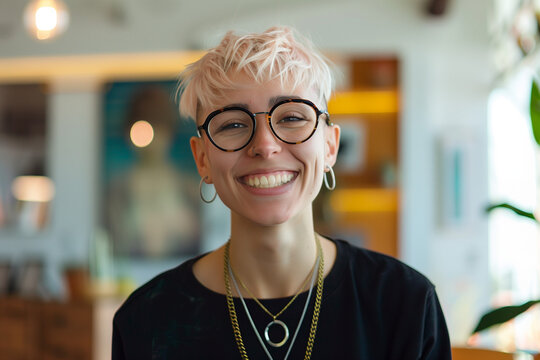 cool young person with bleached short hair wearing jewellery and glasses portrait in modern office, diversity	
