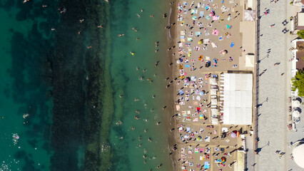 Sudak, Crimea - September 15, 2020: Embankment of Sudak. Black sea coast with beaches and people, Aerial View, HEAD OVER SHOT