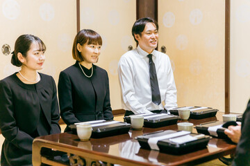 親族・遺族で集まった法事・お彼岸・お葬式の食事シーン（笑顔）
