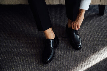 Man ties his black shoes. Close-up view