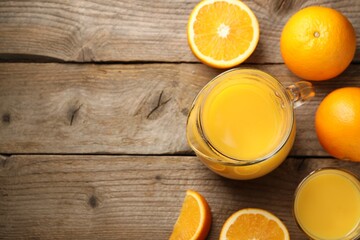 Tasty fresh oranges and juice on wooden table, flat lay. Space for text