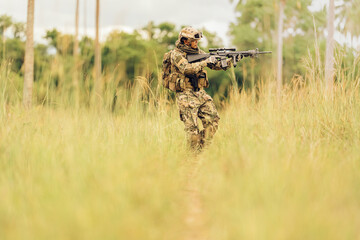 A military patrol carries an M16 rifle. Aim at the target in the jungle battlefield. Prepare to...
