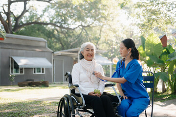 Elderly asian senior woman on wheelchair with Asian careful caregiver. Nursing home hospital