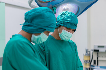 Focused surgeons performing surgery in operating room. Group of surgeons doing surgery in hospital operating theater.