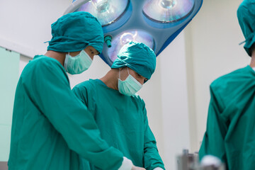 Focused surgeons performing surgery in operating room. Group of surgeons doing surgery in hospital...