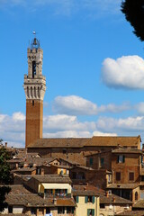 Fototapeta premium View of the tower of the Palazzo Pubblico, in the foreground the old town of Siena, Italy