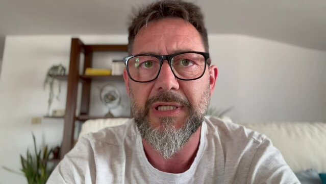 one mature man in webcam view talking with people remote and enjoy online communication. Adult male alone at home  speaking at laptop or phone camera