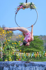 Beautiful Asian girl performing show aerial hoop or aerial ring in various positions and spinning...