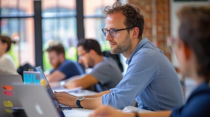 Open-plan office filled with people working on laptops, collaborating, and brainstorming in modern setting.