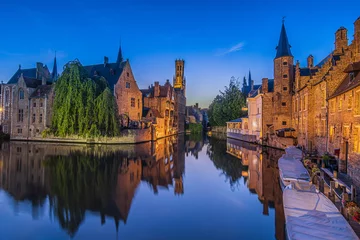 Foto auf Glas Evening atmosphere in the old town of Bruges. Canal of the Rosary Quay in the Hanseatic city. Reflection on the water surface of the historic buildings with tower belfry © Marco