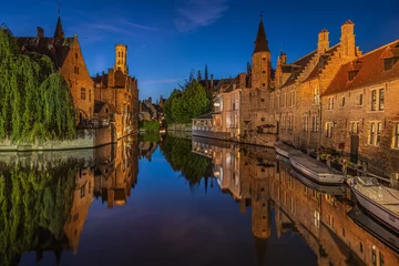 Keuken spatwand met foto Bruges canal in the evening. Rosary Quay in the center of the old town of the Hanseatic city. Illuminated historic merchant houses with reflections on the water surface. Boats at the jetty © Marco