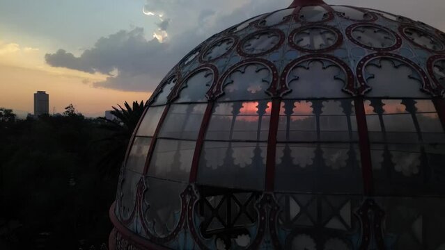 Drone shot of the glass dome of Alameda de Santa Maria and the eagle statue on top at sunset, Mexico
