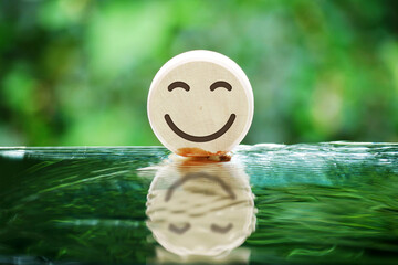 Smiling face on wooden cube surface, world mental health day concept, customer reviews