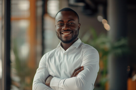 Portrait of a handsome smiling African American businessman at office workplace, professional confident looking young business man at office, positive looking executive manager wearing casual shirt