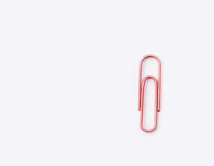 Obraz premium A red paper clip is sitting on a white background