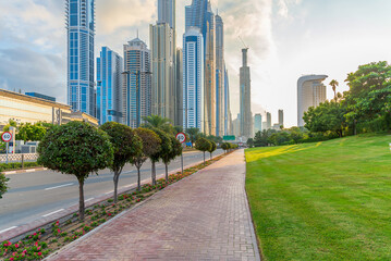 Fototapeta na wymiar Sunset in the Dubai Marina area. View of skyscrapers from the sidewalk