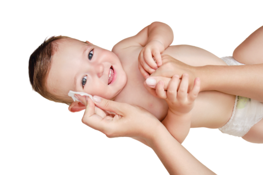 A mother washes the face of a happy toddler baby boy with a cotton pad, isolated on a white background. Mom cleanses the skin of a smiling child, isolated on a white background. Kid age one year