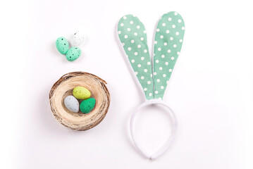 Colorful decorations with Easter egg nest and rabbit ears on white background. copy space, top view