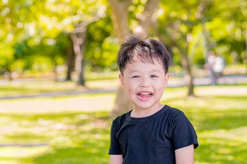 Happy little boy playing at park. Nature background. Copy space.	