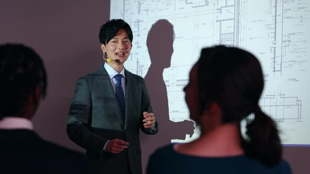 プロジェクターを使ってプレゼンテーションする男性