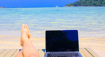 Summer view with Nomad digital as laptop  which running remotely and bright scenic view near poolside on the beach in summer time