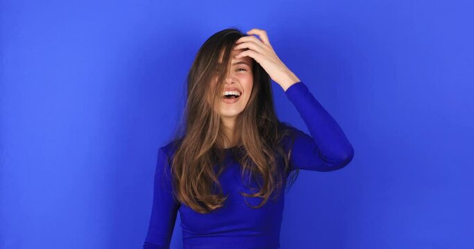 Amazed excited woman win in lottery in pink long sleeves top open mouth in surprise looking at camera with big eyes, shocked isolated on blue background. Oh my god wow, yes gesture, win symbol.