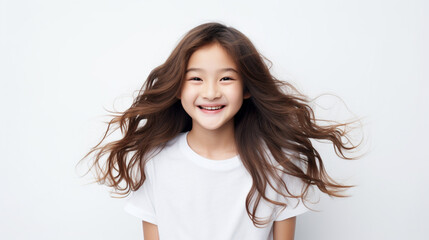 Smiling teenage girl in a white T-shirt on a white background mockup. Childhood lifestyle concept. Mockup copy space. Asian girl model