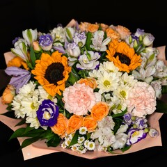 Spring bouquet of various flowers on a dark background.