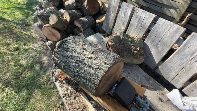 Splitting firewood with an electric log splitter in the garden, 4k