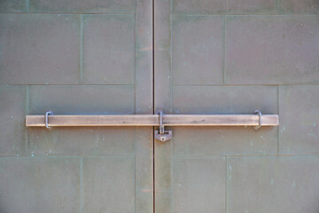 古い扉に通してあるかんぬき棒と錠前