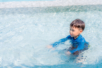 Fototapeta na wymiar Happy little boy learning to swim. Selective focus. Copy space. 