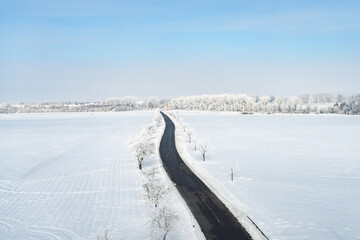 Empty road leading through a snowy winter landscape