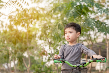 Little boy learns to riding a bicycle at park. Copy Space.