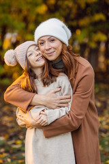Mother and daughter smiling and hugging