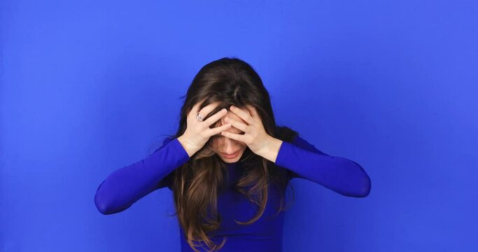 Frustrated nervous woman mad touch head against blue background. Annoyed irritated young woman with an angry face looking furious, mad and feeling frustrated, yelling she look shocked, facepalm, wtf.