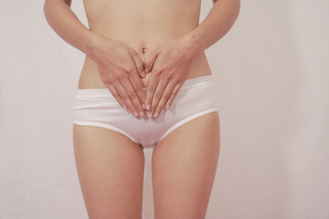 Close-up of woman wearing white panties On a white background about menstruation, cervical cancer, ovarian cancer. - obrazy, fototapety, plakaty