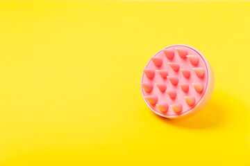 Brush for scalp massage on a yellow background. Brush for hair growth stimulating brush. Hair massage. stimulating brush. Hair care, head relaxation concept. Copy space.
