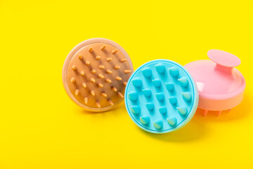 Brush for scalp massage on a yellow background. Brush for hair growth stimulating brush. Hair massage. stimulating brush. Hair care, head relaxation concept. Copy space.