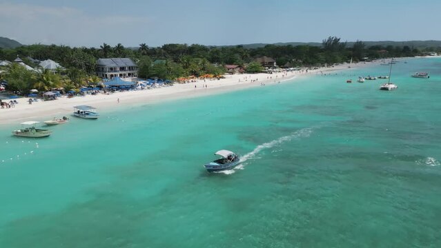 Aerial video above vacationing people and boats on jamaica coastline