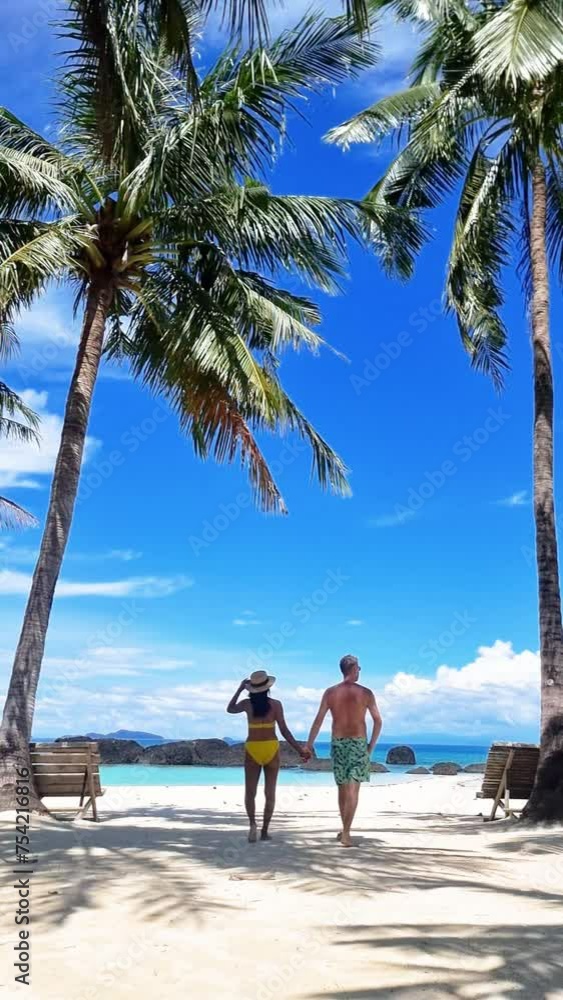 Sticker A couple is strolling along the sandy beach, intertwined hands, under the vast sky with gentle waves brushing their feet and palm trees rustling in the breeze Koh Mak, Thailand, Koh Kham