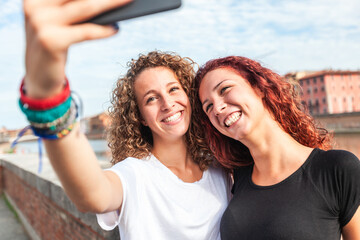 Happy girls taking a selfie in the city