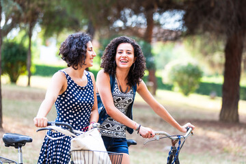 Joyful friends on a leisurely bike ride in the park - 754221202