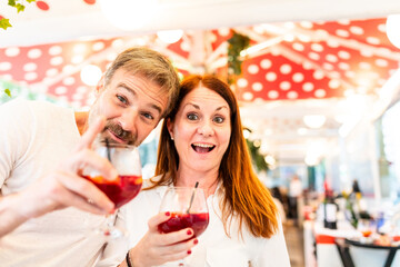 Cheerful couple enjoying drinks at an outdoor cafe in Barcelona