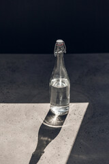 objects and drinks concept - glass bottle of water on sunny floor - 754223072