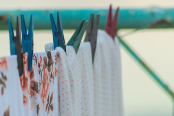 Colorful clothes after washing are hung on a clothesline to dry in the wind, bed linen, sheets....